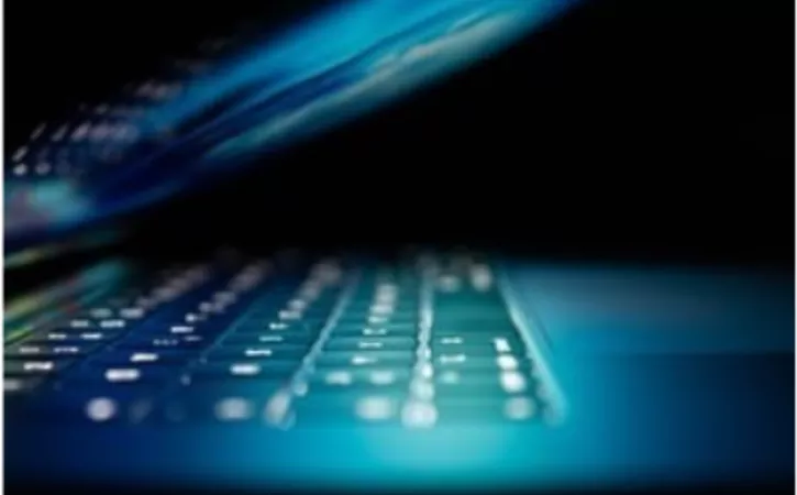 a mostly closed laptop with blue light